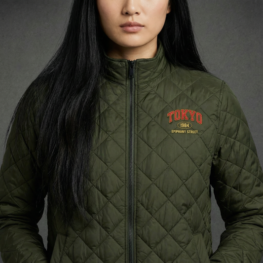 Person wearing a green quilted jacket with 'Tokyo 884' text on a gray background