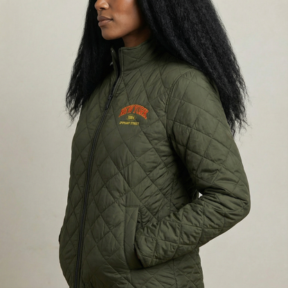 Person wearing a green quilted jacket with a brand logo on a neutral background