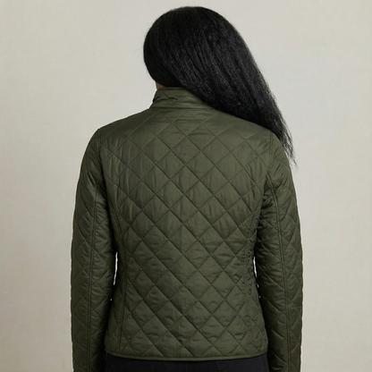 Person wearing a green quilted jacket against a neutral background