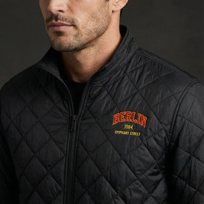 Man wearing a black quilted jacket with 'Berlin 1984' text on a dark background