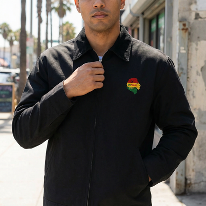 Man wearing a black jacket with a colorful logo on a street background