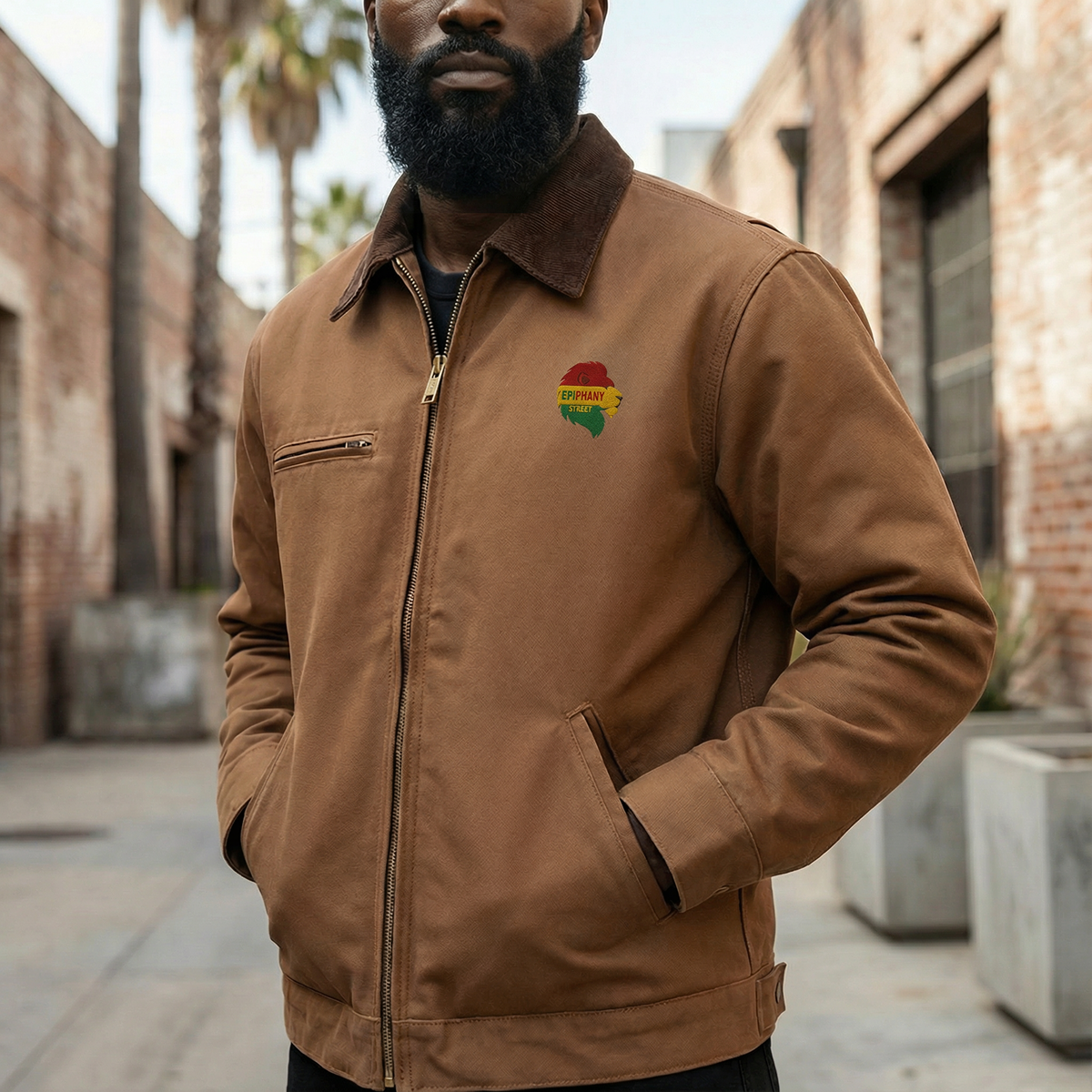 Man wearing a brown jacket with a colorful logo in an urban setting