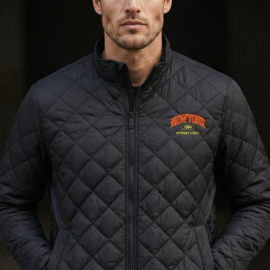Man wearing a black quilted jacket with a brand logo on a dark background