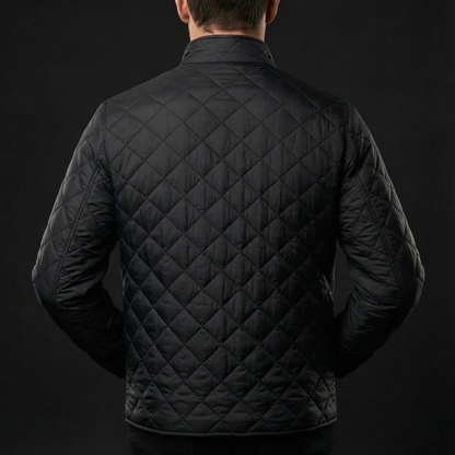 Black quilted jacket worn by a person on a black background