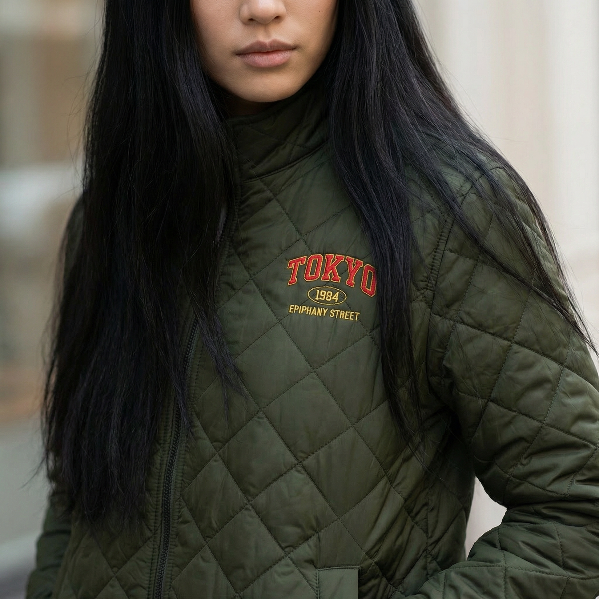 Person wearing a green quilted jacket with 'TOKYO 1984' text.
